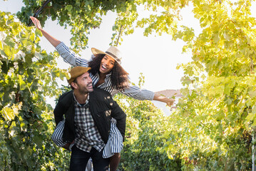 happy young interracial couple on holiday in a vineyard.