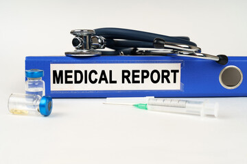 On a white surface, a syringe, a stethoscope and a folder with the inscription - MEDICAL REPORT