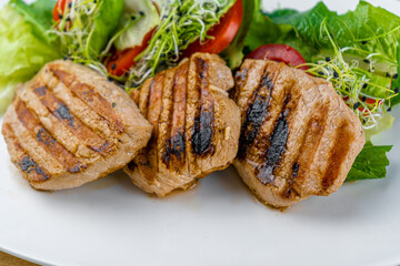 Meat with vegetables. Pork medallions. Grilled meat. Cutlets close-up. Beef Food