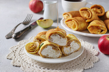 Homemade thin pancakes with cottage cheese and apples for breakfast. Close-up