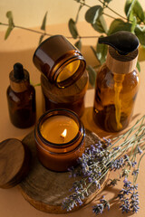 Soy candles in a glass jar. Aromatherapy. Burning candle and lavender. Wooden lid for jars. Beige background. Comfort and relaxation. Handmade. Home decor.