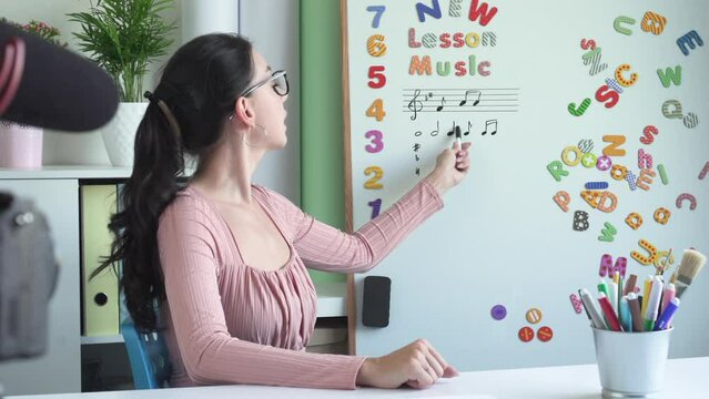 A young woman Influencer making online live streaming and  answers subscribers' questions. Vloger using a video camera at home. Feedback and reverse communication.