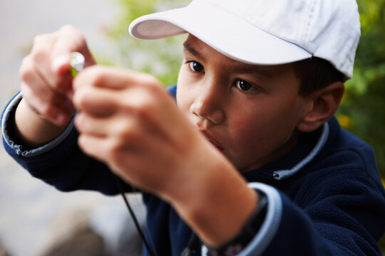 Boy Putting Lure on Fishing Rod, Algonquin Park, Ontario, Canada