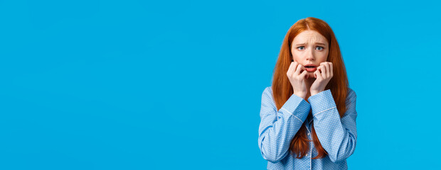 Scared and panicking young worried redhead teenage girl having sleepover with girlfriend, telling...