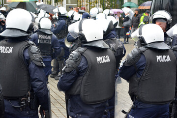 Drużyna policjantów prewencji z tarczą i gazem na zabezpieczeniu.