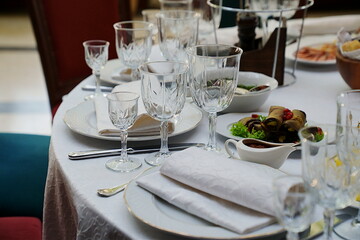 table setting for a festive dinner. empty wine glasses, tableware and snacks.