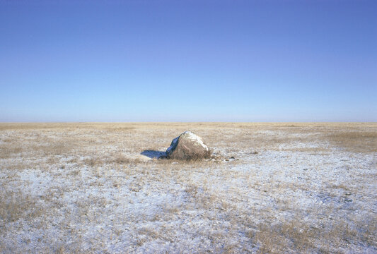 Large Rock in Snowy Field near Loring, Montana, USA