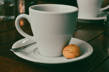  a cup of espresso  coffee served with a cookie on wooden table. Vintage, romantic coffee concept