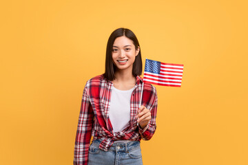 Education abroad, studying in the US, emigration concept. Happy asian female student holding american flag - obrazy, fototapety, plakaty