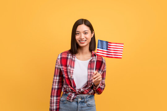 Education Abroad, Studying In The US, Emigration Concept. Happy Asian Female Student Holding American Flag