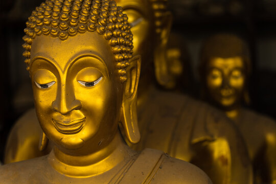 Closeup image of buddha's face statue with other buddha statues as background. This photo represents the concept of meditation, peaceful, calm, religious and meditation.