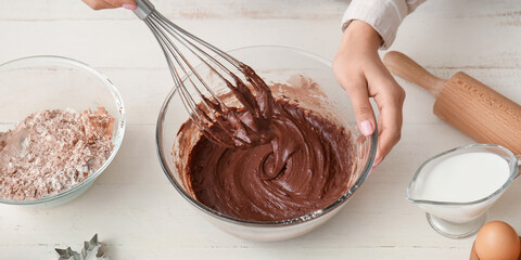 Woman preparing fresh chocolate dough at kitchen table