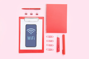 Stationery supplies and mobile phone with WiFi symbol on color background