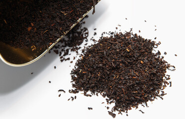 Fragrant dry large tea scattered from the package with bergamot on a white background. Tasty with...
