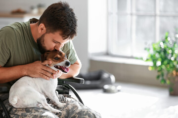 Young soldier in wheelchair with dog at home