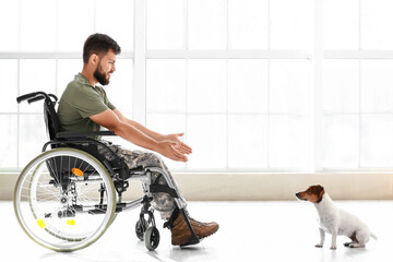 Young soldier in wheelchair with dog at home