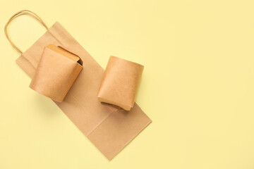 Paper boxes and bag on color background