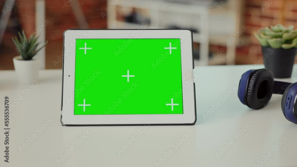 Poster empty office space with digital tablet showing green screen on display, used to work on technology a