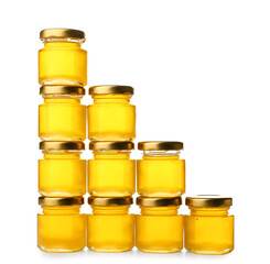 Delicious honey in jars on white background