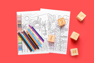 Coloring pages, pencils and cubes on red background