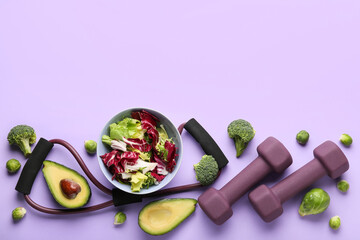 Bowl with vegetable salad, dumbbells and expander on color background