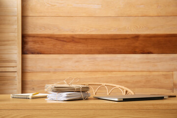 Notebook, stack of tied letters and laptop on wooden table. Mail concept
