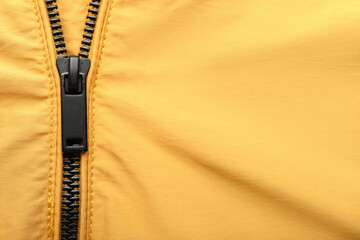 Black zipper on yellow clothes, closeup
