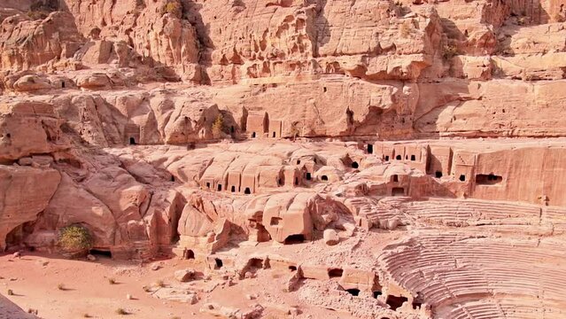 Slow motion panning view cave houses in Petra site with theater monument