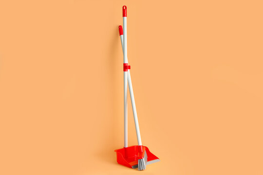 Cleaning broom and dustpan on color background