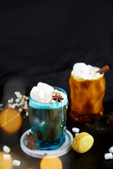 Viennese coffee with macaroons, marshmallows, cinnamon and cardamom. Christmas drinks. Bokeh effect