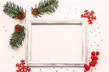 Composition with empty picture frame and Christmas decor on light background