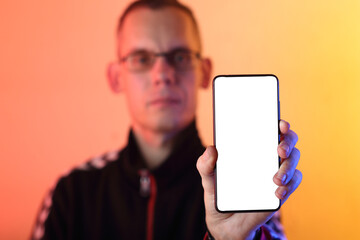 smartphone with a white screen vertically in the hand against the backdrop of a person