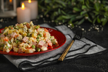 Plate of tasty Olivier salad on dark background, closeup