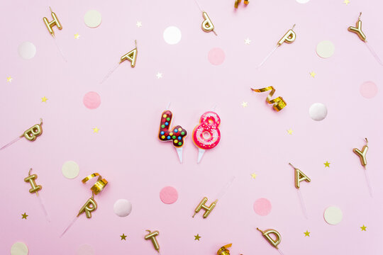 Numerals 48 in the form of sweet donuts are surrounded by festive decor. Forty eight year birthday celebration concept. Selective focus
