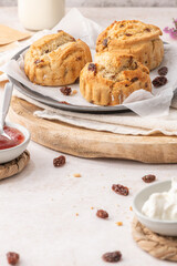 Homemade raisin scones with clotted cream and strawberry jam ready to eat