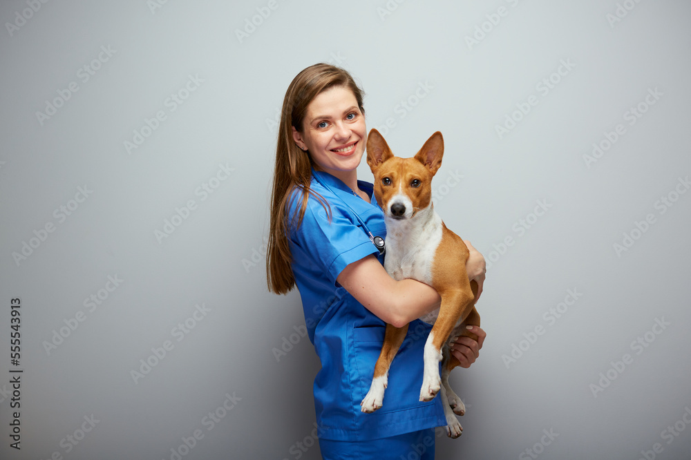 Wall mural smiling veterinarian doctor holding dog isolated portrait.