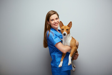Smiling veterinarian doctor holding dog Isolated portrait. - 555543913