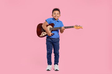 African-American boy with electric guitar on pink background