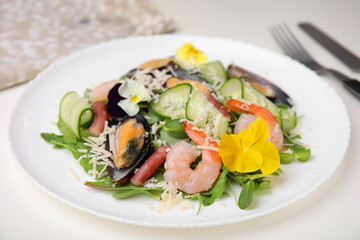 Plate of delicious salad with seafood on white table