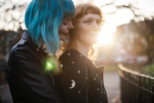 unconventional lesbian couple embrace in park at sunset