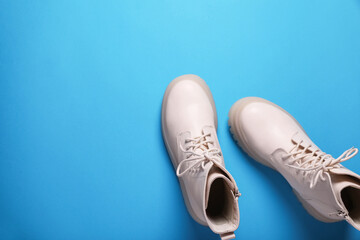 Pair of stylish leather shoes on light blue background, flat lay. Space for text