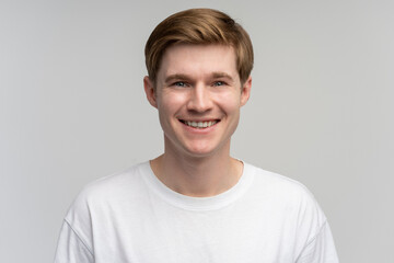 Portrait of happy successful caucasian man standing, looking at camera with positive smile