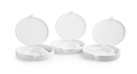 Containers with dental mouth guards on white background. Bite correction
