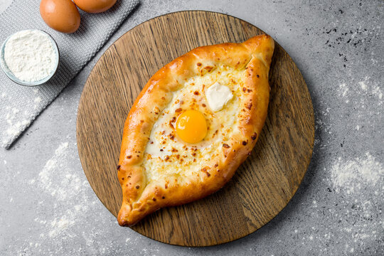 ajara Khachapuri with cheese, egg and butter, georgian kitchen on grey table top view
