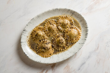 ravioli with prosciutto cotto and truffle on marble table top view
