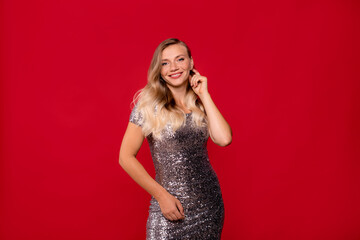 smiling woman posing on red background. Advertising of fashionable evening party clothing.