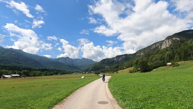 Cycling along a cycle path in Bohinj during summer under a blue sky