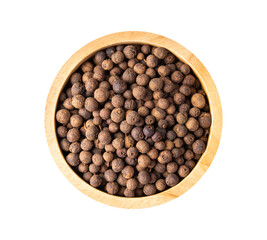 Allspice berries (also called Jamaican pepper or newspice) in wood bowl on white background. top view