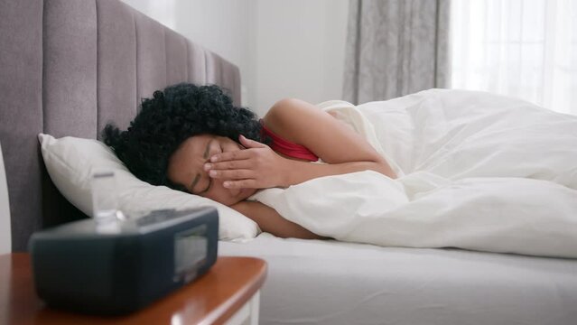 Woman of color crying thinking of problem. Frustrated mixed race black girl suffer from anxiety insomnia. Depressed upset african american woman feeling sad lonely lying in bed alone trying to sleep