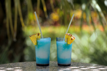 Two cocktail glasses on marble table and green background and copy space